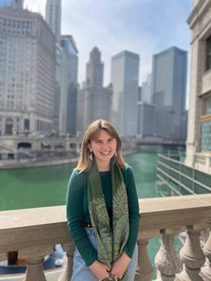 Messy Jesus Business blog contributor Cassidy Klein wearing green sweater and scarf in front of Chicago skyline
