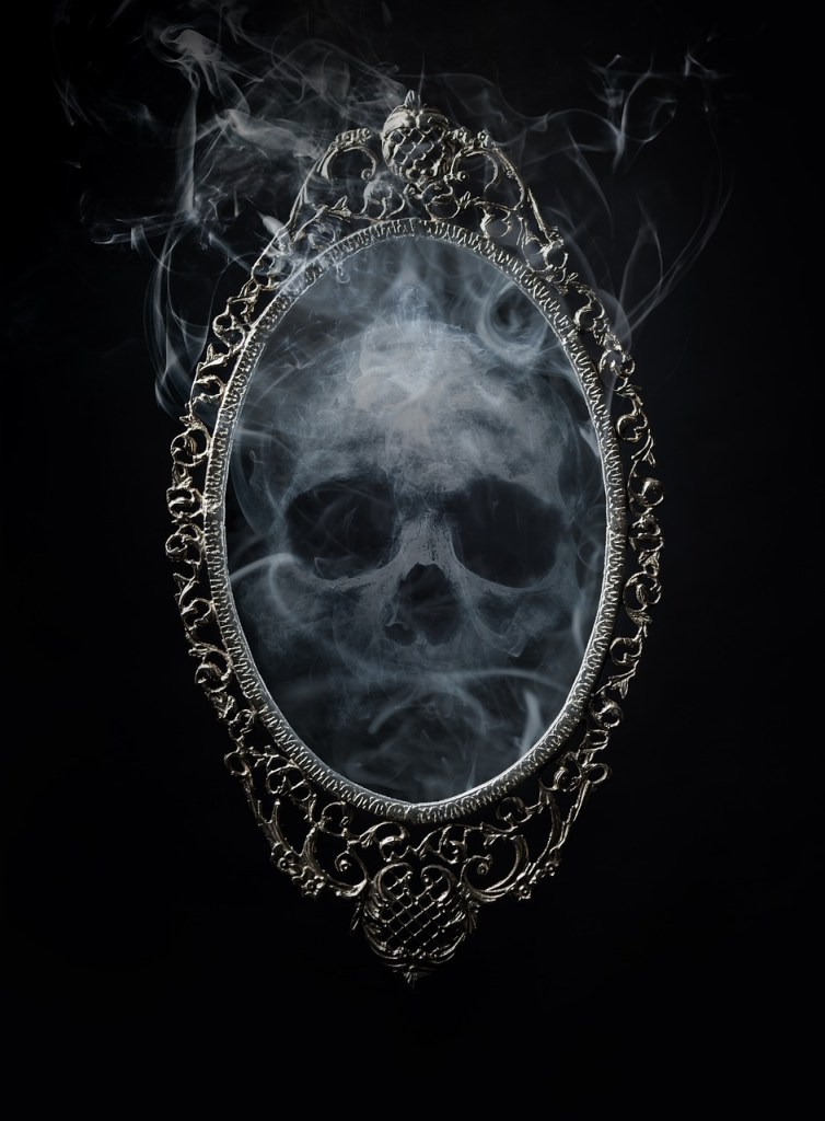black and white image of a skull made of smoke reflected in an ornate mirror
