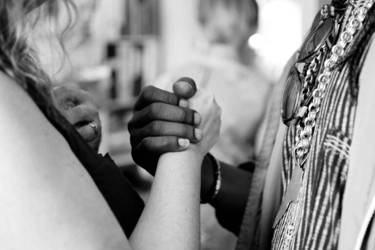 A black hand and a white hand clasped