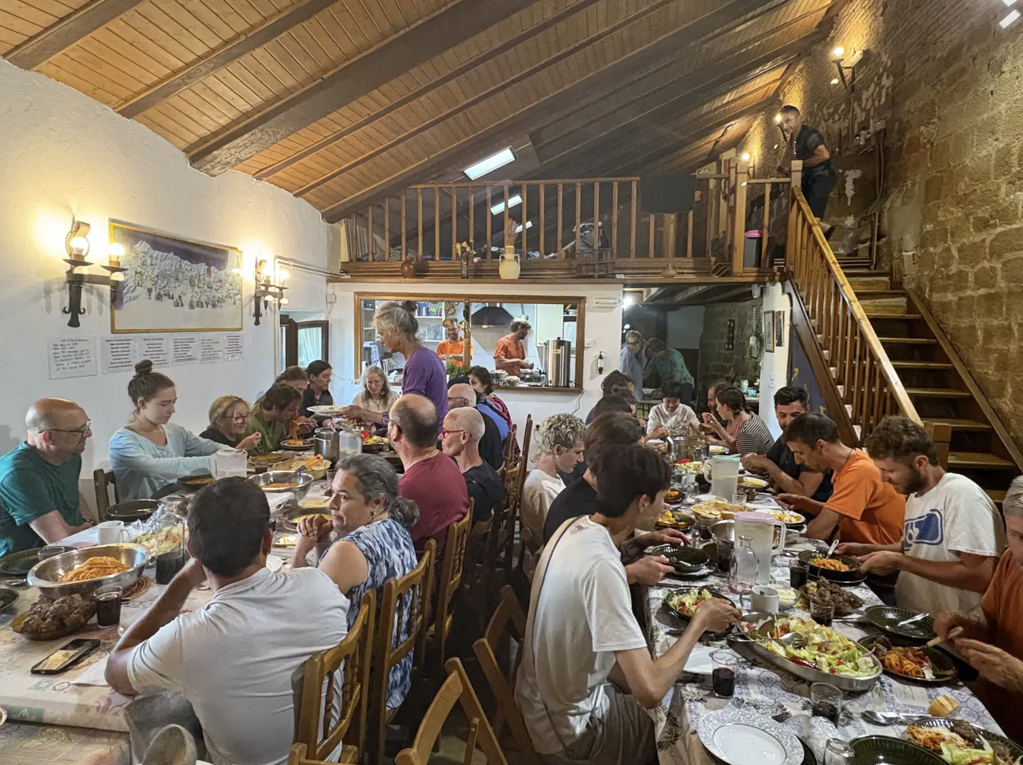 Two long tables full of people set with a feast.